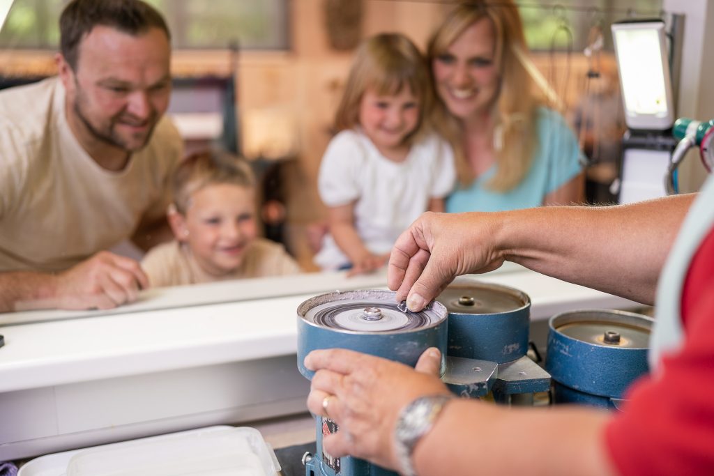 Eine Familie sieht zu, wie ein Granatstein geschliffen wird. Eine Familie sieht zu, wie ein Granatstein geschliffen wird.