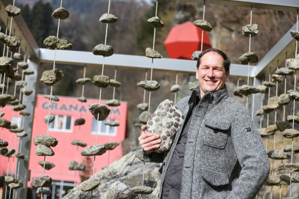 Manfred König, der Geschäftsführer des Granatium in Radenthein, lächelt und steht vor dem Granatium Haus.
