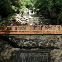 Eine Holzbrücke in der Granatschlucht, auf der sich Menschen befinden.