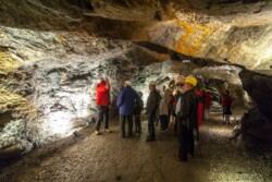 Eine Gruppe von Erwachsenen steht im Stollen im Granatium und sieht sich den Stollen an.