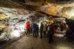 Eine Gruppe von Erwachsenen steht im Stollen im Granatium und sieht sich den Stollen an.