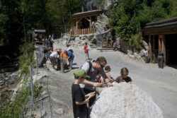 Erwachsene und Kinder sowie Familien befinden sich auf einem Ausflug am Schürfgelände des Grantium und schürfen Granatsteine.