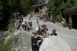 Erwachsene und Kinder sowie Familien befinden sich auf einem Ausflug am Schürfgelände des Grantium und schürfen Granatsteine.