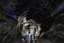 Eine Familie macht einen Familienausflug und steht im Karfunkelstollen.