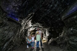 Eine Familie macht einen Familienausflug und steht im Karfunkelstollen.