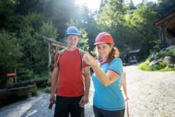 Ein Mann und eine Frau stehen auf dem Schürfgelände des Granatium und die Frau hält einen Granatstein in der Hand.