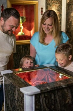 Eine Familie schaut sich das Granatzimmer in der Erlebniswelt Granatium Radenthein an.